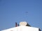 Airplane flying above an industrial shed.