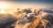 Airplane flying above mountains and low clouds at sunset