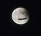 Airplane flying across a full moon