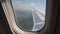 Airplane flying in the air on ponds, lakes, swamps. View through porthole window