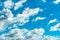 Airplane flying on beautiful blue sky and white cumulus clouds. Cloudscape background. Blue sky and fluffy clouds on sunny day.