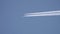 Airplane flying in blue sky with condensation trail
