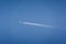airplane flying high in the sky with vapor trails