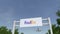 Airplane flying over advertising billboard with FedEx logo. Editorial 3D rendering 4K clip