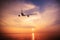 Airplane flying over amazing tropical ocean at sunset. Thailand travel