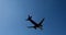 Airplane flying over head in sunny blue sky