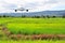 Airplane frying over the green rice flied Mountain background