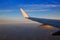 Airplane jet wing at sunset with golden sunlight