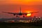 Airplane is landing during sunrise.