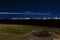 Airplane light trails over distant airport at night