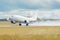 Airplane lit by the sun takes off in a wet runway during the rain at the airport.