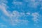 Airplane in the middle of the blue sky with puffy clouds