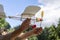 Airplane model with a propeller made from household waste plastic on a background of the sky in the hands of grandfather