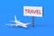 Airplane near billboard with word travel