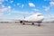 Airplane parked at the airport against the backdrop of a blue scenic skyline with clouds. World aviation concept