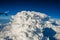 Airplane passing by huge cumulonimbus cloud