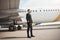 Airplane pilot enjoying sunshine near plane wing