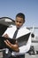 An Airplane Pilot Taking Notes At Airfield