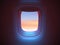 Airplane porthole in the evening ambient atmosphere with clouds sunset visible through window. In pink blue color scheme