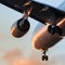 Airplane ready to landing or takeoff at sunset, bottom view, close up of wing, engine and chassis