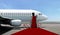 Airplane with red carpet on airport taxiway under blue sky