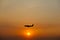 Airplane silhouette over sunset