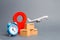 Airplane and stack of cardboard boxes, red position pin and blue alarm clock. concept of air cargo and parcels, airmail. Fast