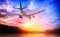 Airplane in the sunset sky flight travel transport airline background concept.