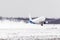 Airplane take off from the snow-covered runway airport in bad weather during a snow storm, a strong wind in the winter.