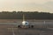 Airplane taxis in the terminal after landing evening light sunset