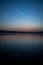 Airplane trail reflection in the calm lake