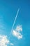 Airplane vapor trail or contrail pattern on blue sky with clouds