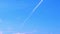 Airplane vapour trails across clear blue sky