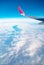 Airplane window view with a wing and curved Earth below bright sky heaven