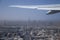 Airplane Wing and Clouds Viewed from Inside the Aircraft, with Dubai sky line and Burj Khalifa in background. Travel concept with