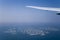 Airplane Wing and Clouds Viewed from Inside the Aircraft, with Dubai The World Islands in background. Travel concept with copy