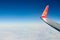 Airplane wing with coat of arms of Ukraine over clouds aerial top view from aircraft window