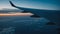 Airplane wing in dim light at blue hour