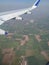 Airplane wing and fields aerial view from aeroplane window