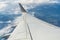 Airplane wing in flight above the clouds, horizon of the earth.