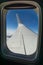 Airplane wing in flight through porthole window