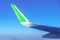 Airplane wing with green stripe. Travel with eco friendly airline. Reducing carbon emissions concept.