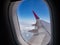 Airplane wing over blue sky and white cloud view looking through airplane window. Travel, vacation and journey concept