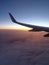 airplane wing in pink clouds photo in flight from a porthole