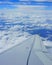 Airplane wing in the sky. View from airplane porthole, blue sky