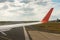 Airplane wing and take-off runway window view from the passenger cabin. Aircraft heading to the take-off position.