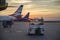 Airplanes at the airport at sunset. Unloading luggage at the airport.