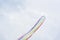 Airplanes on airshow with colorful bright trails of smoke against a blue sky, clouds. Aircraft, flying display and
