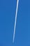 Airplanes leaving diagonal trace on a clear blue sky.