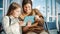 Airport Airplane Terminal: Cute Mother and Little Daughter Wait for their Vacation Flight, Play e-